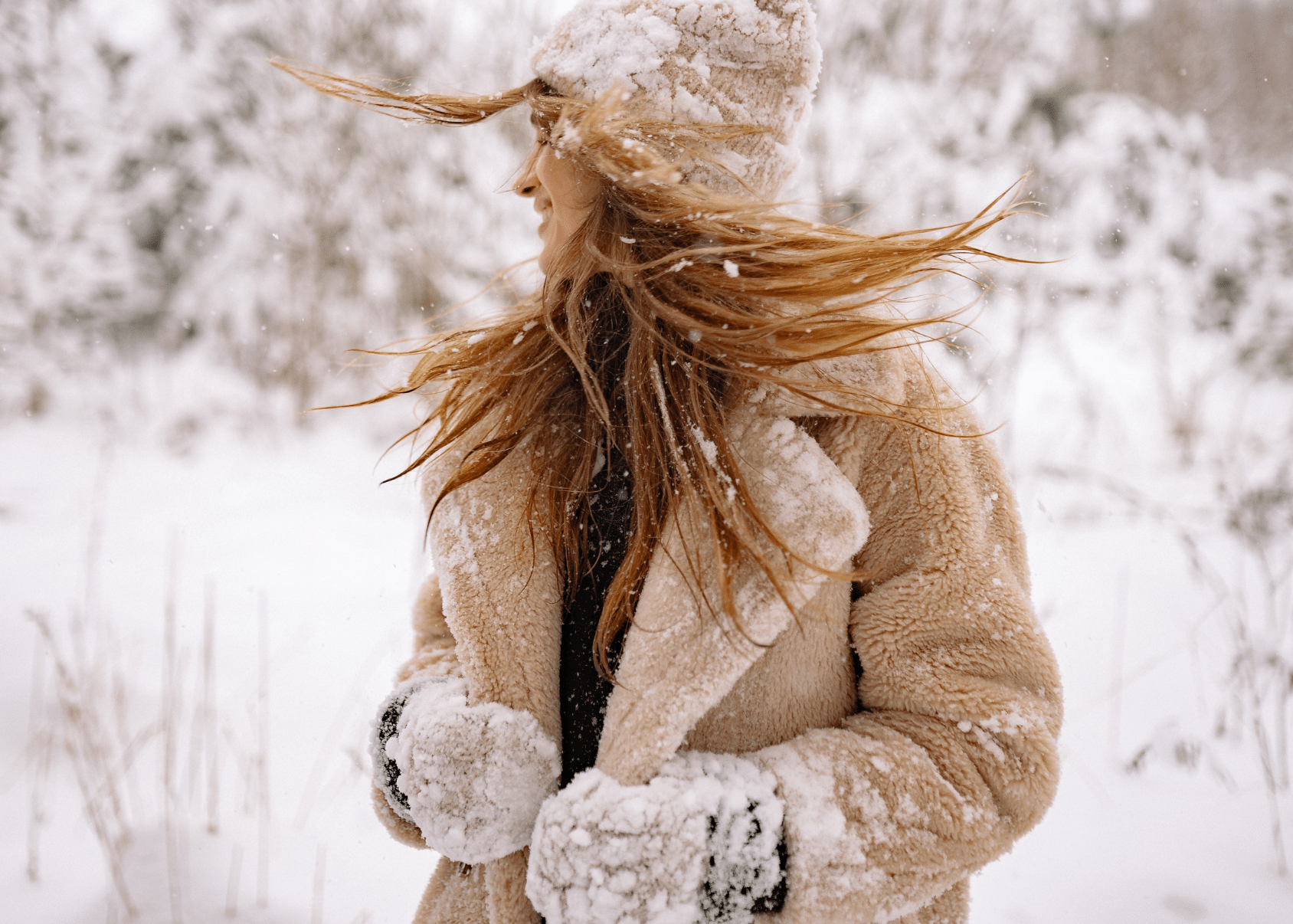 Woman swishing her hair in snowy surrounds